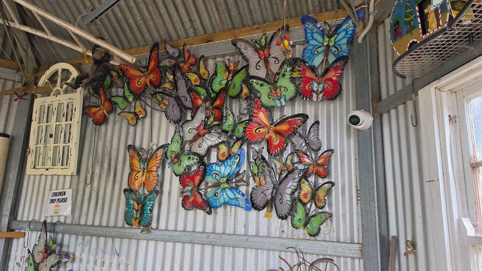 Colourful metal butterflies on a corrugated iron wall